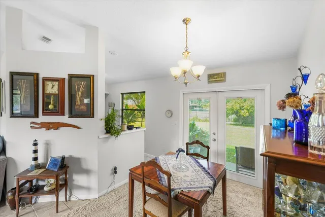a view of a dining room with furniture a livingroom and chandelier