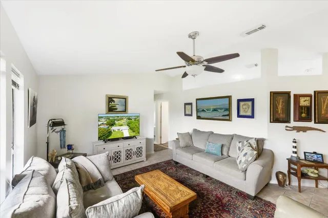 a living room with furniture ceiling fan and a window