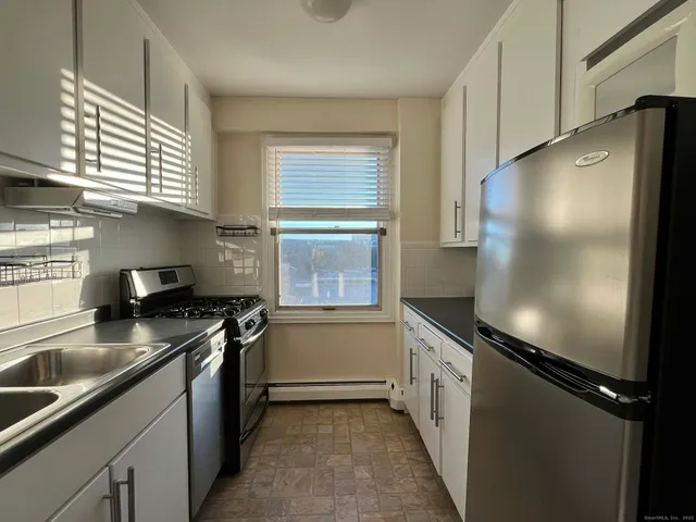 a kitchen with granite countertop a refrigerator and a sink