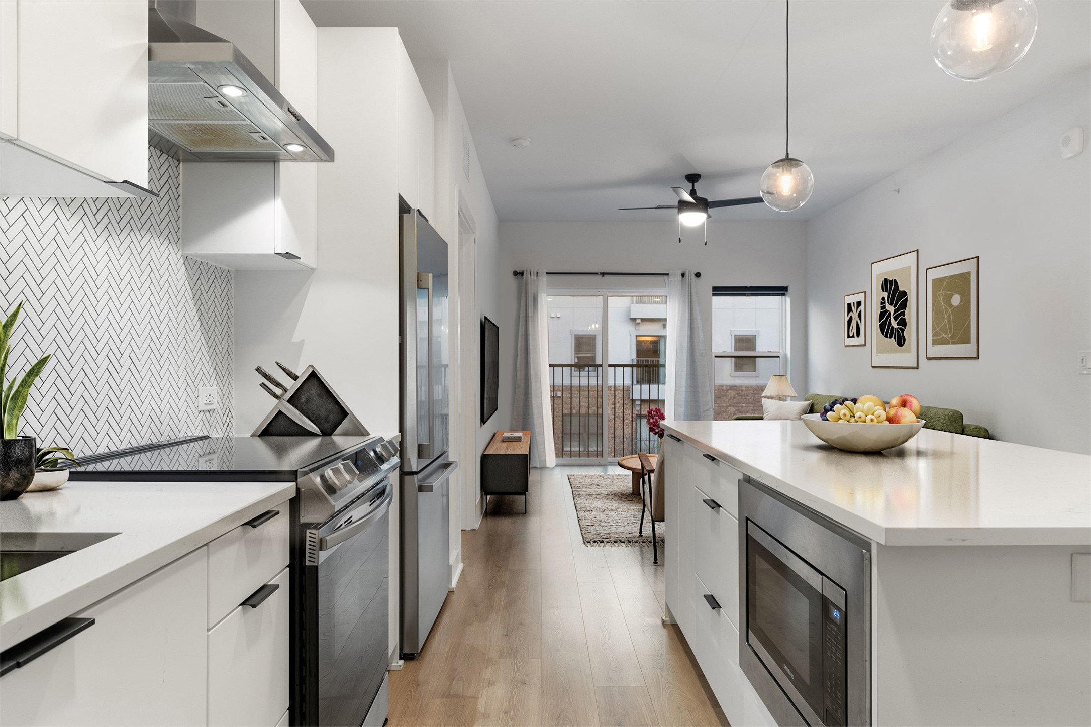 2500 Longview Street, Unit 418 Austin, TX 78705 - Photo 6 of 40 Kitchen featuring white cabinets, stainless steel appliances, wall chimney range hood, decorative light fixtures, and backsplash