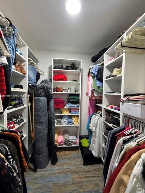 20465 Southwest 200th Street Miami, FL 33187 - Photo 25 of 36 a view of walk in closet with clothes and shoes