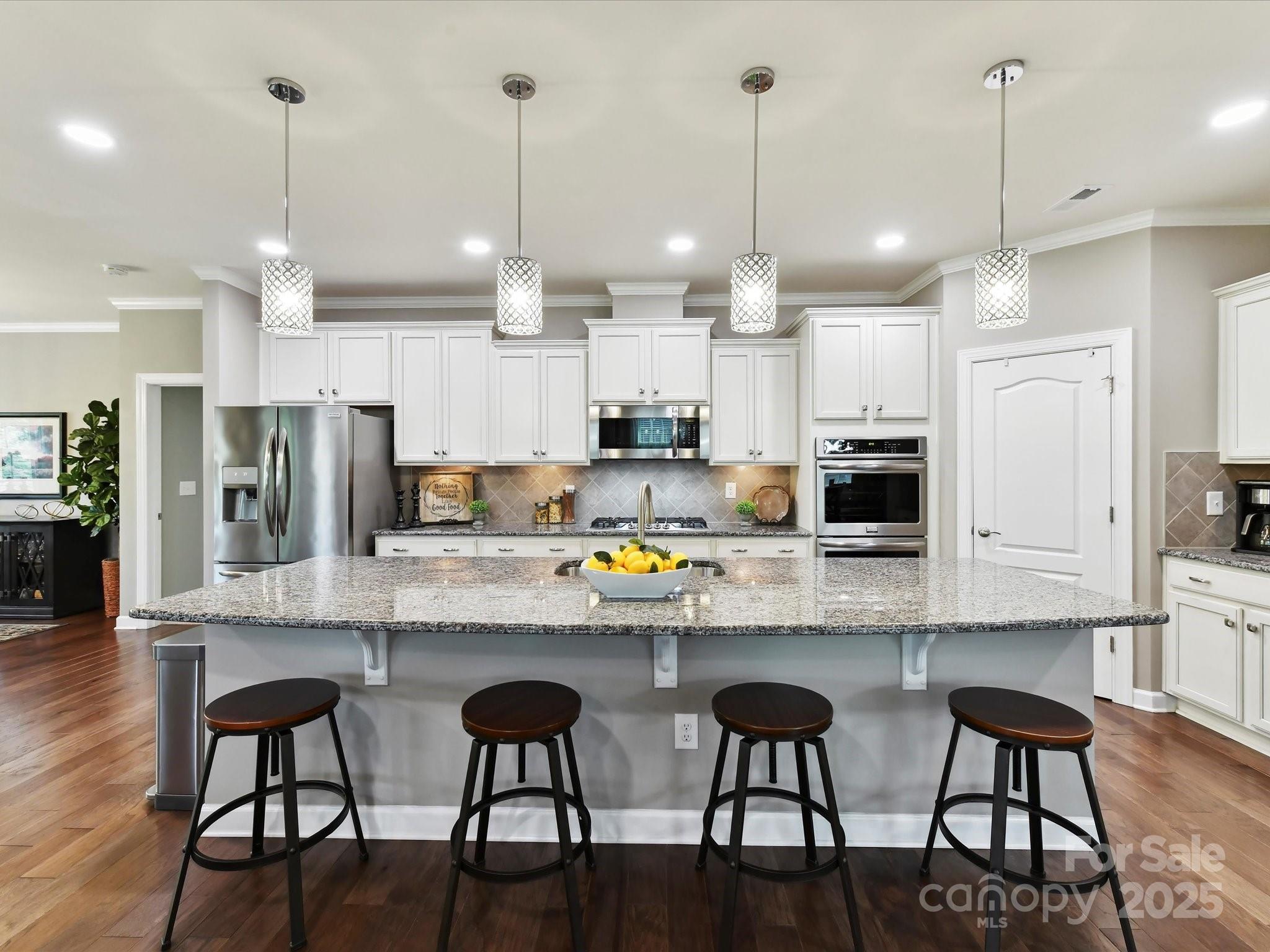 2972 Arches Bluff Circle Lancaster, SC 29720 - Photo 13 of 47 a open kitchen with stainless steel appliances granite countertop a stove a refrigerator a kitchen island a sink and wooden floor