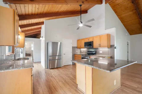 a kitchen with stainless steel appliances granite countertop a sink a stove and a refrigerator