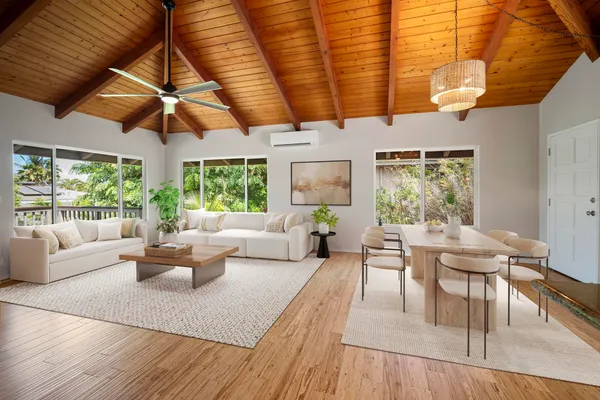 a living room with furniture a large window and wooden floor