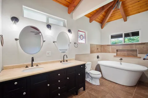 a spacious bathroom with a double vanity sink mirror and bathtub