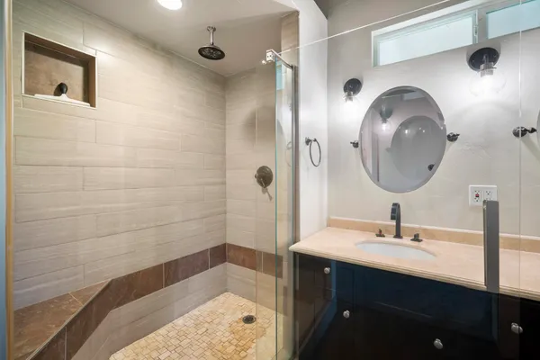 a bathroom with a sink a mirror and shower