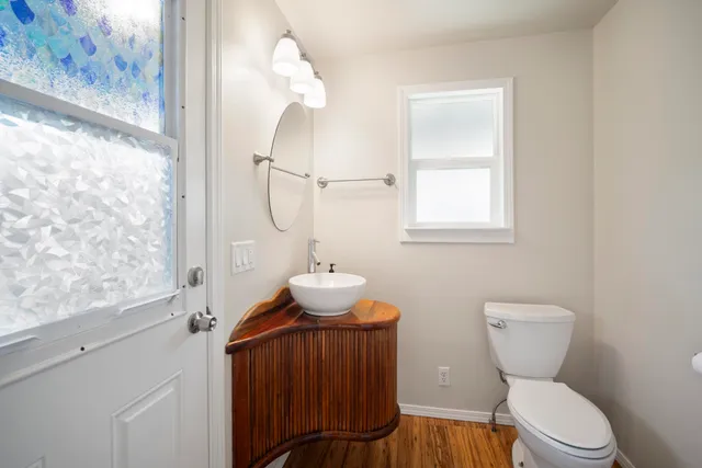 a bathroom with a toilet a sink and mirror
