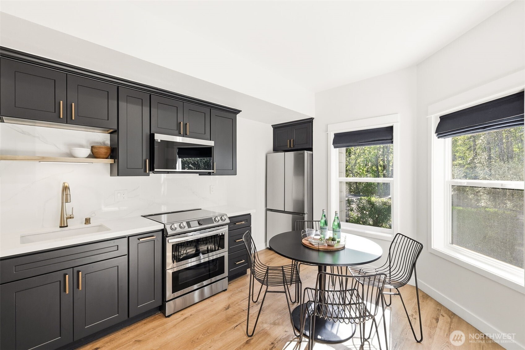 1737 Mt Baker Avenue Northeast Renton, WA 98059 - Photo 31 of 40 a kitchen with stainless steel appliances a dining table chairs and a refrigerator