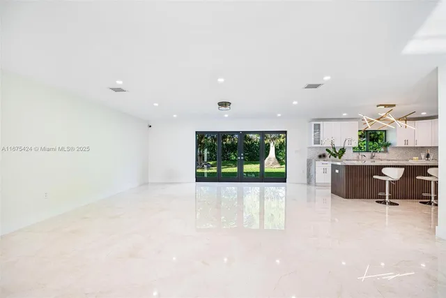 a living room with furniture a window and a flat screen tv