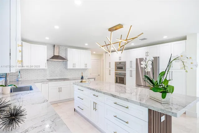 a kitchen with stainless steel appliances kitchen island granite countertop a potted plant on the granite counter tops and a view of living room