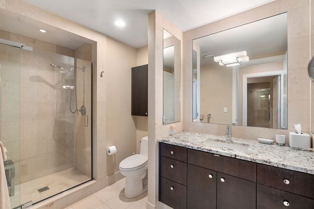 a bathroom with a granite countertop sink mirror and shower