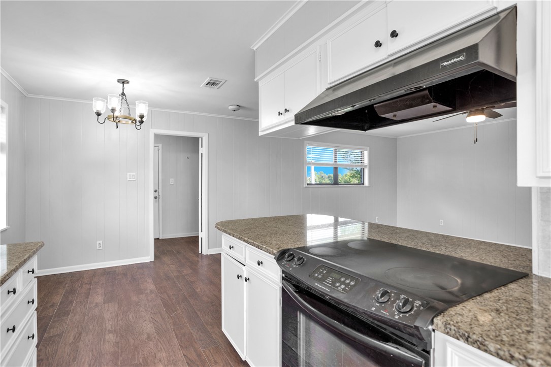 21356 Highway 90 Sabinal, TX 78881 - Photo 17 of 44 Kitchen with electric range, under cabinet range hood, a chandelier, dark wood finished floors, and white cabinets