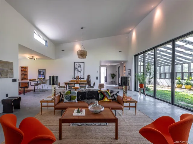 a living room with furniture large window and rug