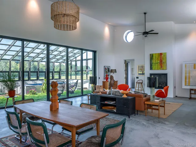 a view of a dining room with furniture a chandelier windows and wooden floor