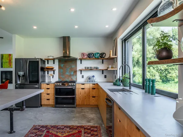 a kitchen with stainless steel appliances granite countertop a stove a sink and a refrigerator