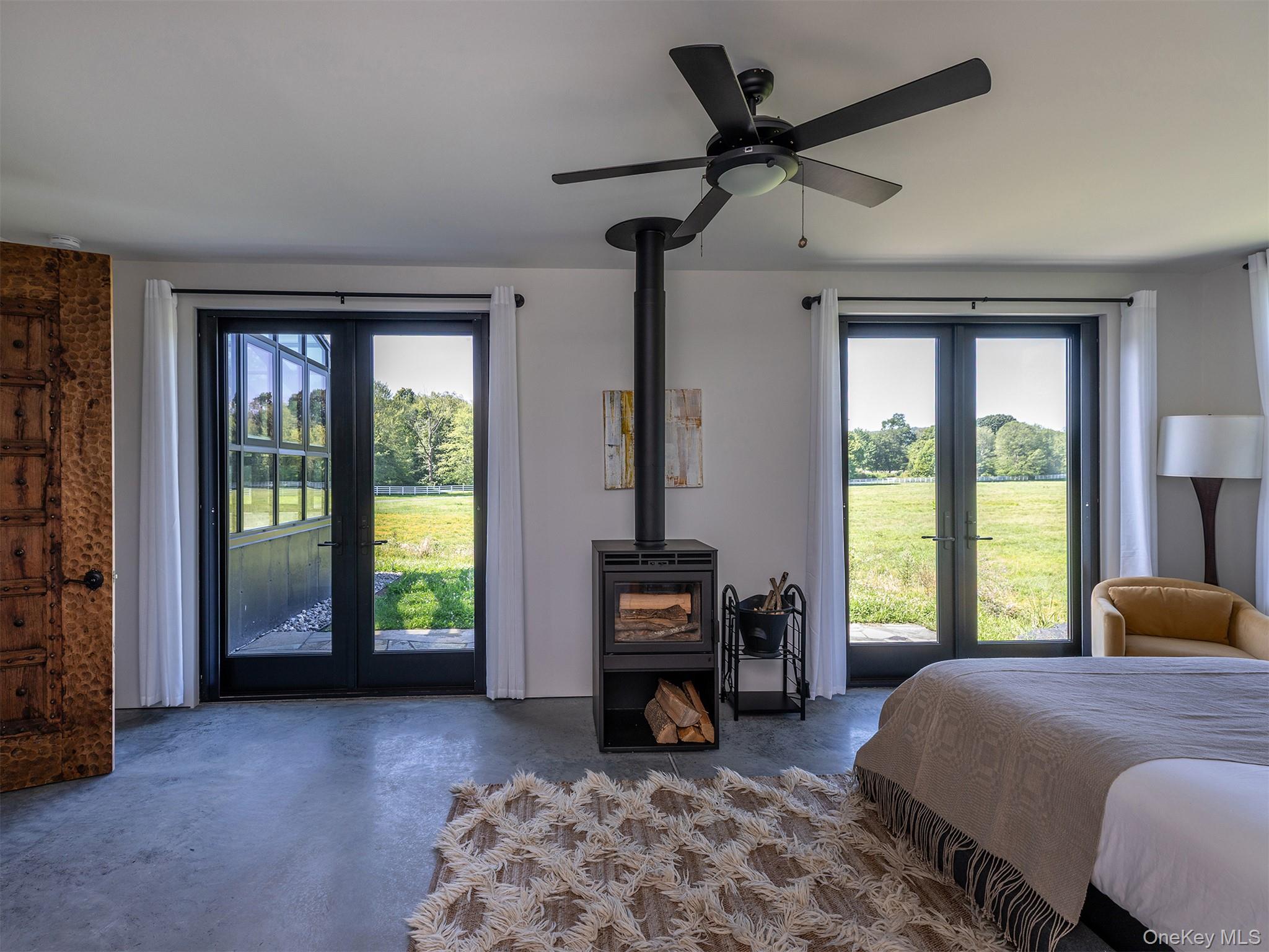 476 Carpenter Hill Road Pine Plains, NY 12567 - Photo 25 of 50 Bedroom with french doors, access to exterior, concrete floors, and a wood stove