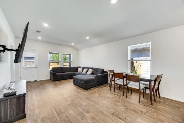 a living room with furniture and a wooden floor