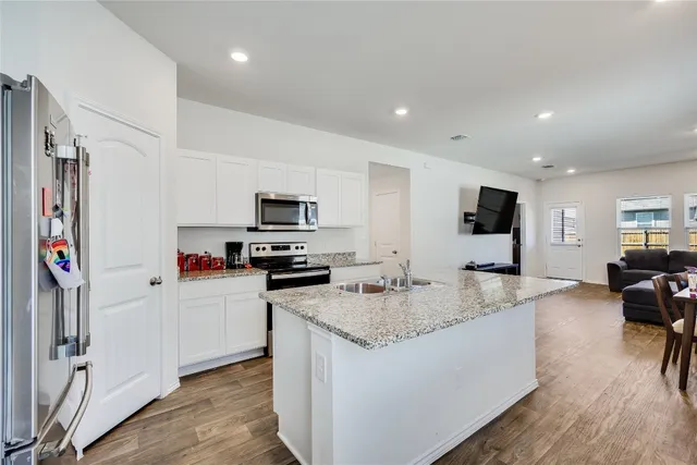a kitchen with stainless steel appliances granite countertop a sink stove and refrigerator