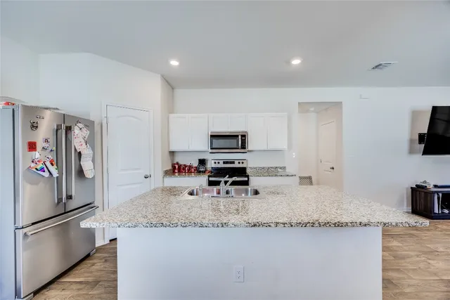 a kitchen with stainless steel appliances granite countertop a sink dishwasher stove refrigerator and microwave