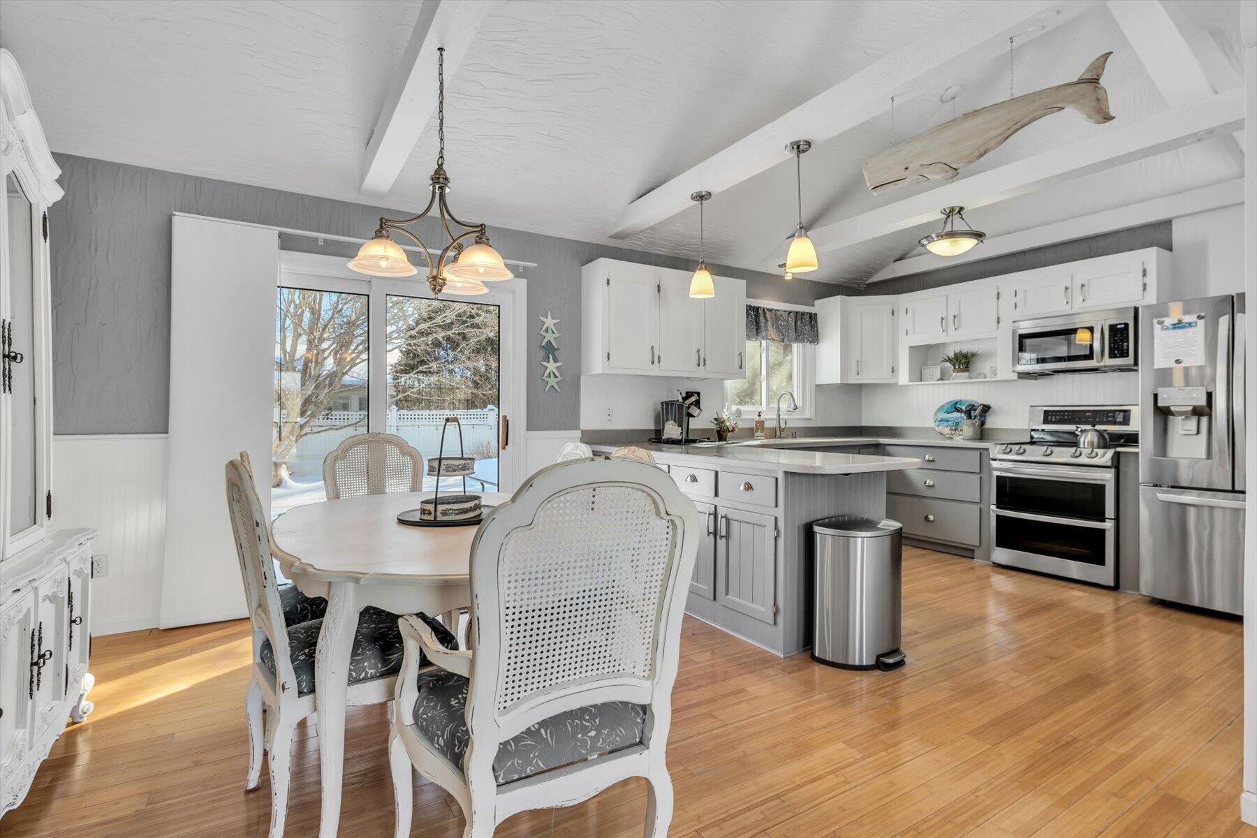 3 McNamara Road West Yarmouth, MA 02673 - Photo 11 of 45 a kitchen with stainless steel appliances granite countertop a stove a refrigerator a sink dishwasher a dining table and chairs with wooden floor