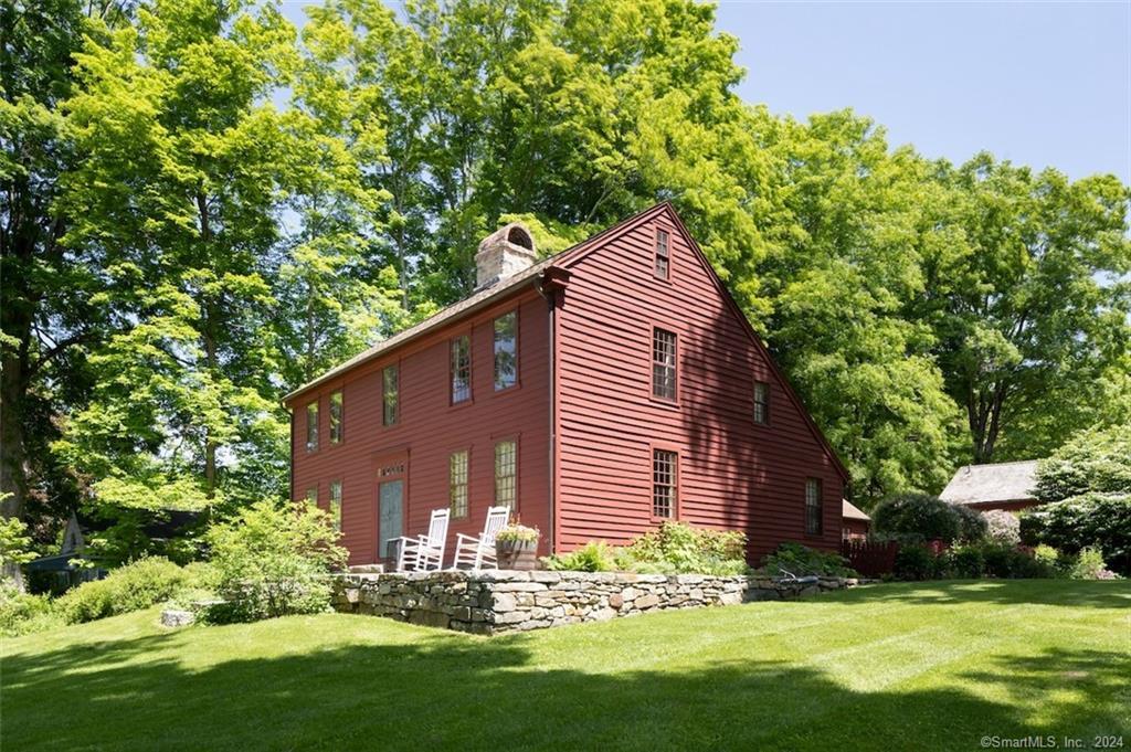 a backyard of a house with large trees and plants