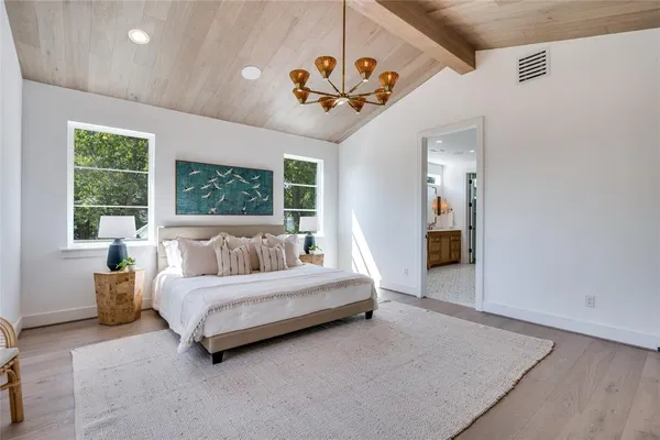 a spacious bedroom with a large bed and a chandelier