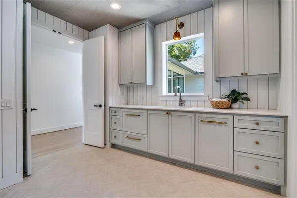 a kitchen with white cabinets and window