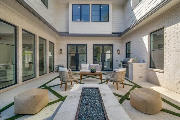 a living room with furniture rug and floor to ceiling windows