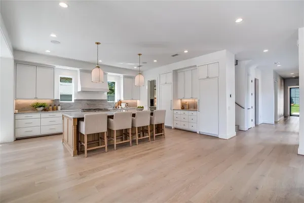 a kitchen with stainless steel appliances kitchen island refrigerator and cabinets