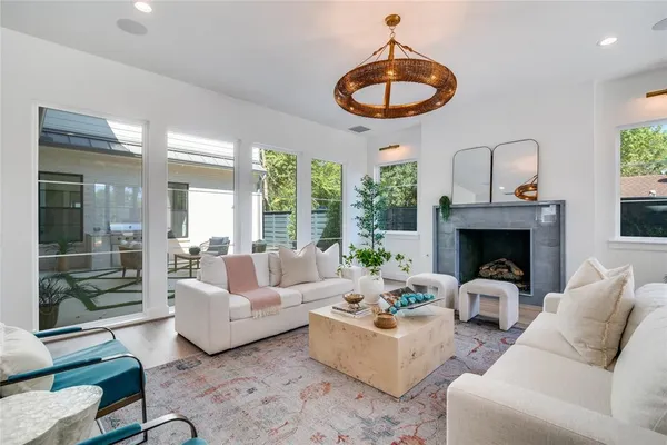 a living room with furniture a fireplace and a large window