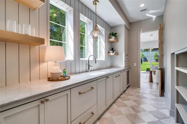 a large white kitchen with stainless steel appliances granite countertop a sink and a large window