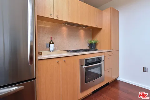 a kitchen with stainless steel appliances granite countertop a sink a stove and a refrigerator