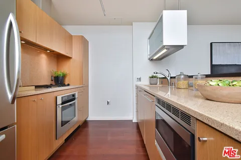 a kitchen with stainless steel appliances granite countertop a sink a stove and a refrigerator