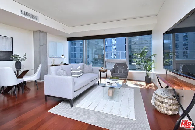 a living room with furniture floor to ceiling window and wooden floor