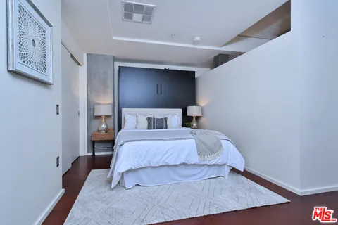 a bedroom with a bed and a night stand