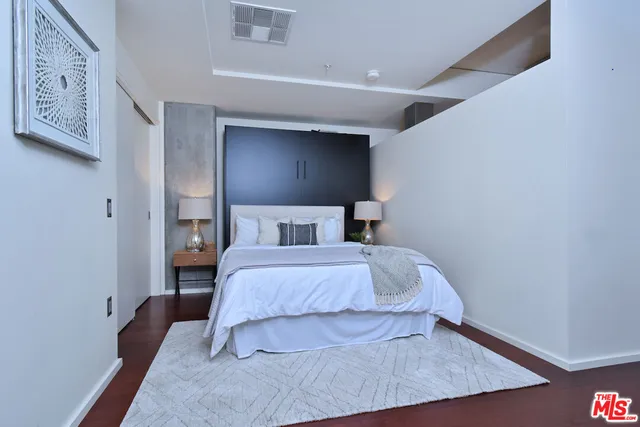 a bedroom with a bed and a night stand