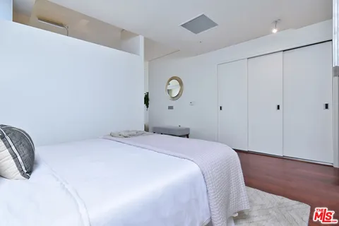 a hallway with a wooden floor and a potted plant