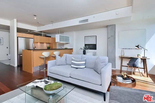 a living room with furniture kitchen view and a flat screen tv