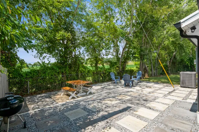 a backyard of a house with table and chairs