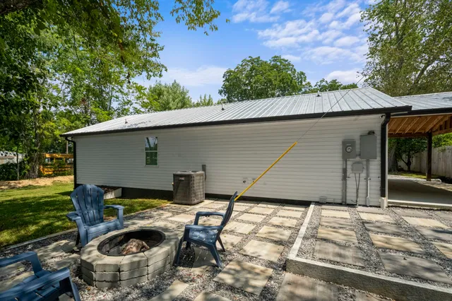 a backyard of a house with yard and outdoor seating