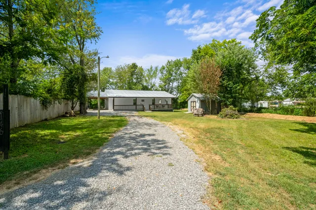 a view of a house with backyard and a tree