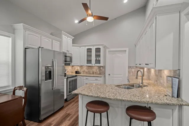 a kitchen with stainless steel appliances granite countertop a sink refrigerator and microwave