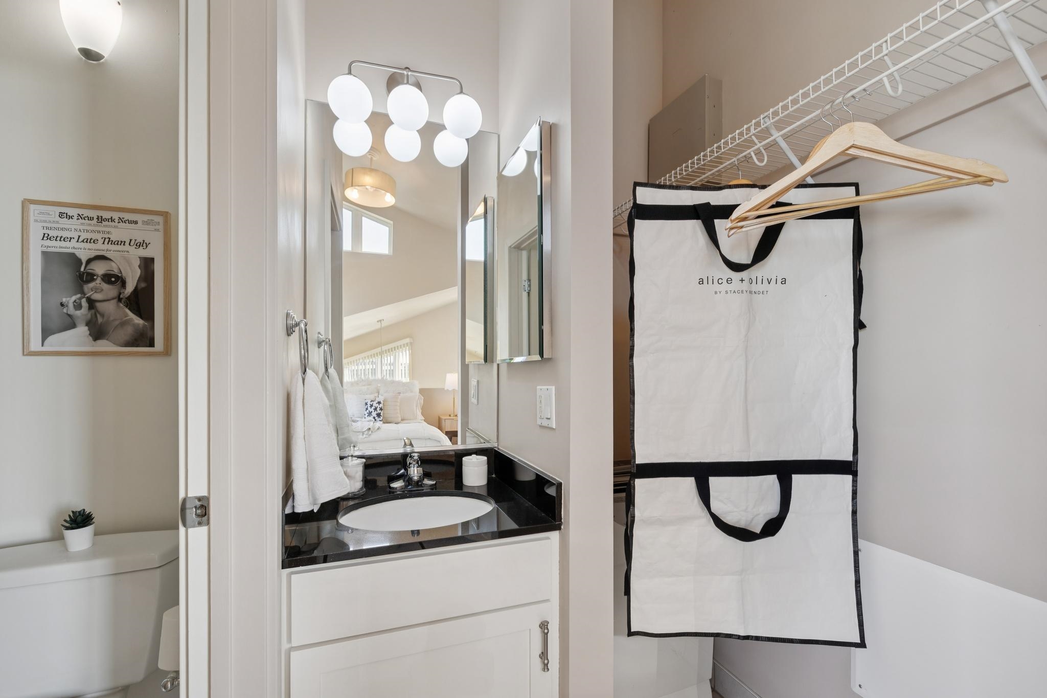675 8th Street, Unit 10 Oakland, CA 94607 - Photo 21 of 40 a bathroom with a granite countertop sink a mirror a vanity and a shower