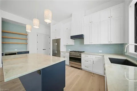 a kitchen with stainless steel appliances a stove a sink and a refrigerator