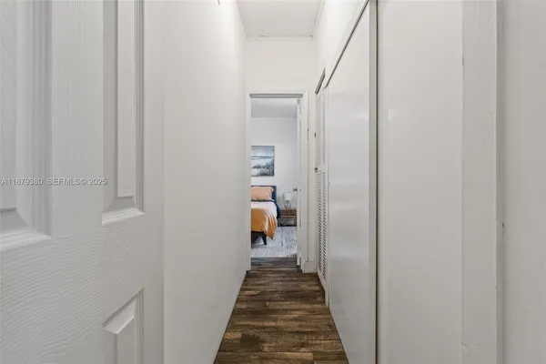 a view of a hallway with wooden floor and entryway