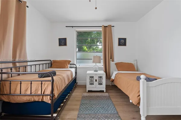 a bedroom with two beds and a window