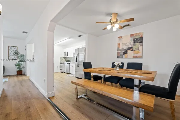 a room with a table chairs and wooden floor