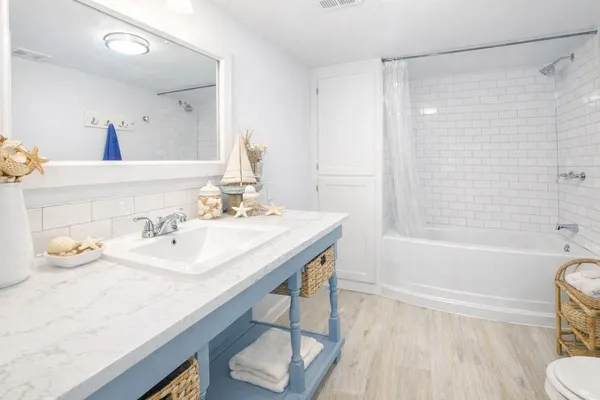 a bathroom with a granite countertop sink a toilet and shower