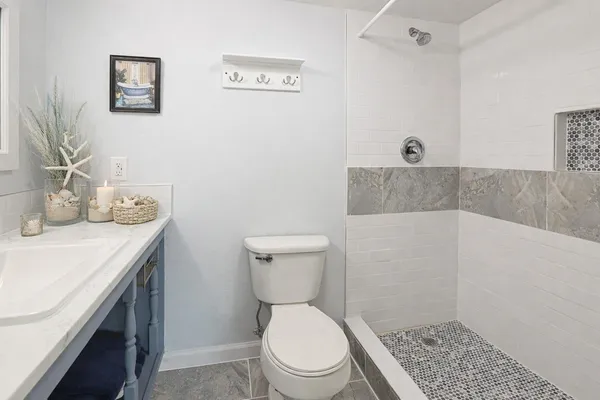 a bathroom with a granite countertop toilet and a sink