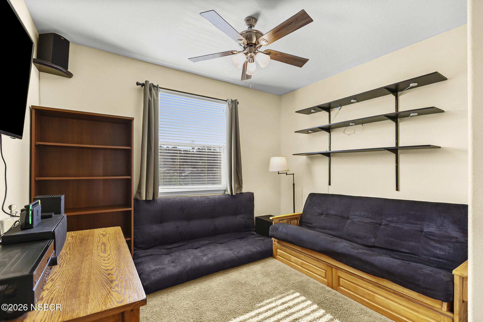 1557 Canyon Creek Road Santa Maria, CA 93455 - Photo 29 of 43 a living room with a couch and a bookshelf with wooden floor